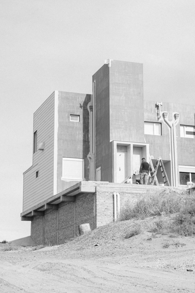Man painting a modern building exterior on a ladder